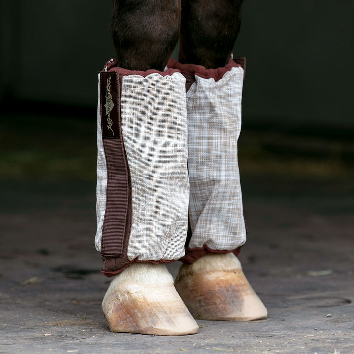 Beige and chocolate bubble fly boots on horse leg.